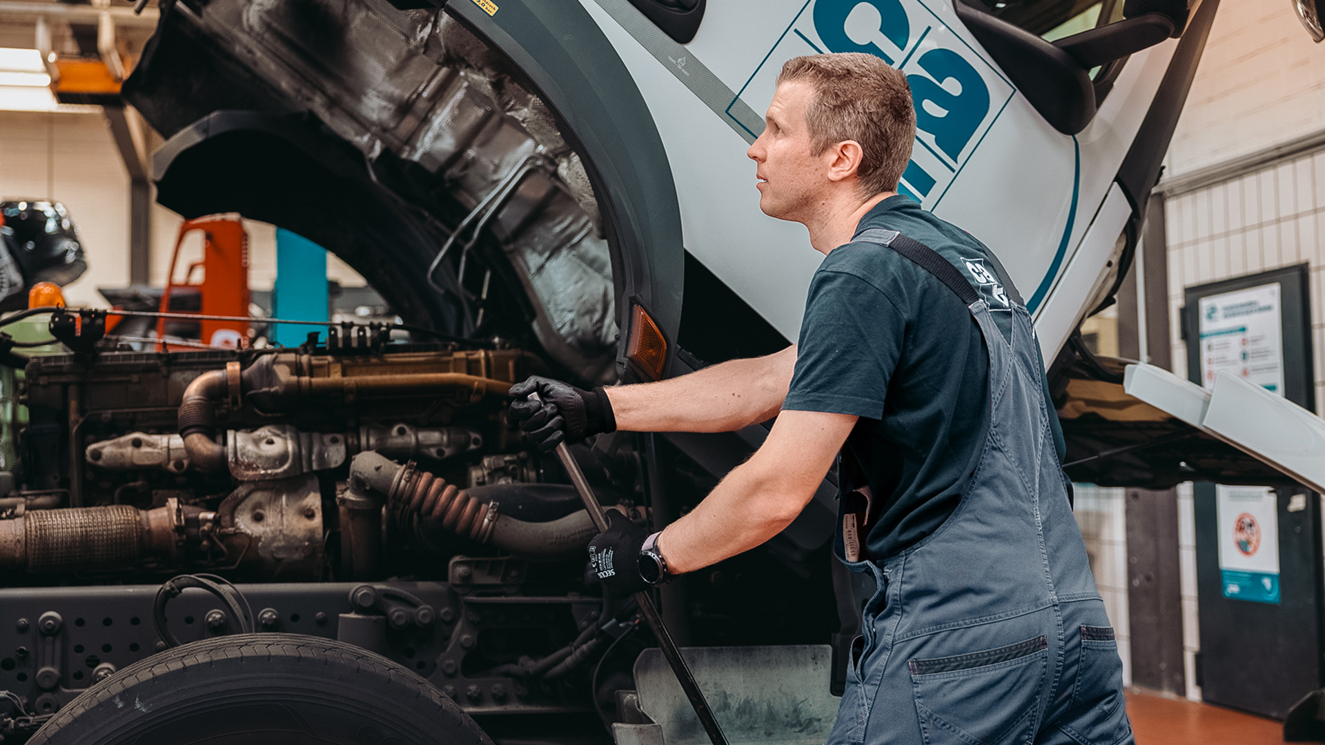 Maintenance en logistique automobile effectuée par un technicien de Groupe CAT sur le moteur d'un camion